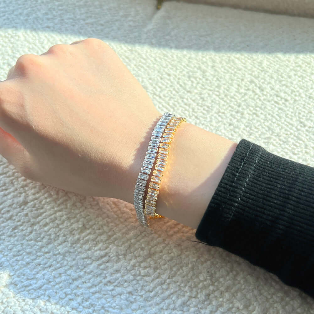 woman wearing gold and silver emerald-cut cubic zirconia bracelets