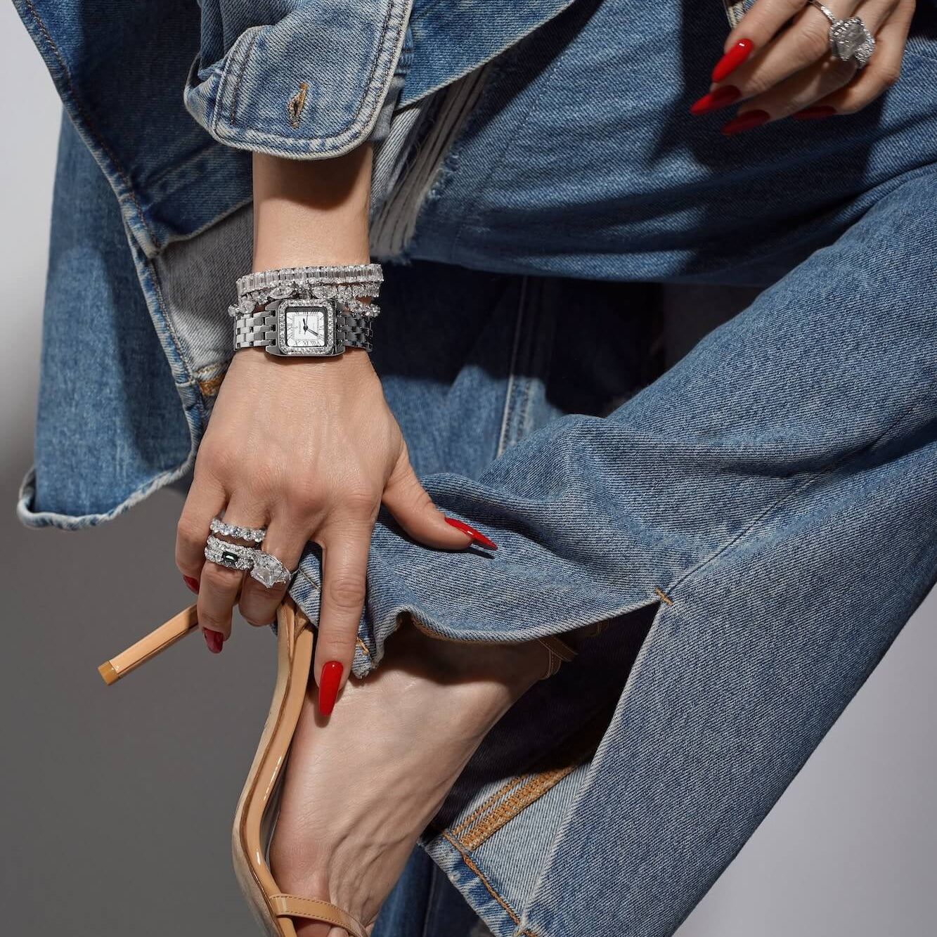 Model wearing denim jeans jacket and high-heeled shoes with a variety of Viviana Halil jewelry pieces