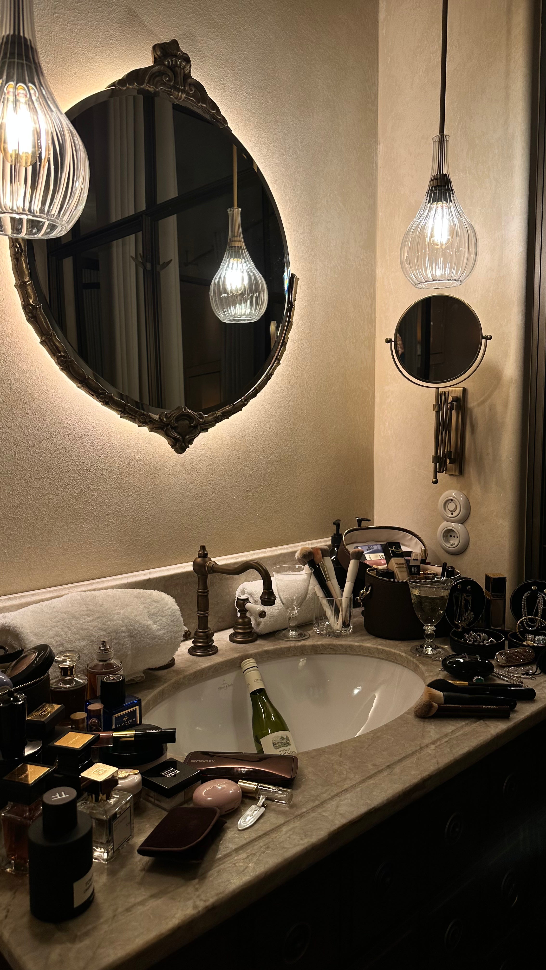 Bathroom vanity displaying The Mini Travel Jewelry Box by Viviana Halil  including a bottle of champagne .