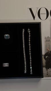 Diamond-free Jewelry by Viviana Halil including ring and earrings displayed on a black stand with 'VOGUE' magazine in the background.