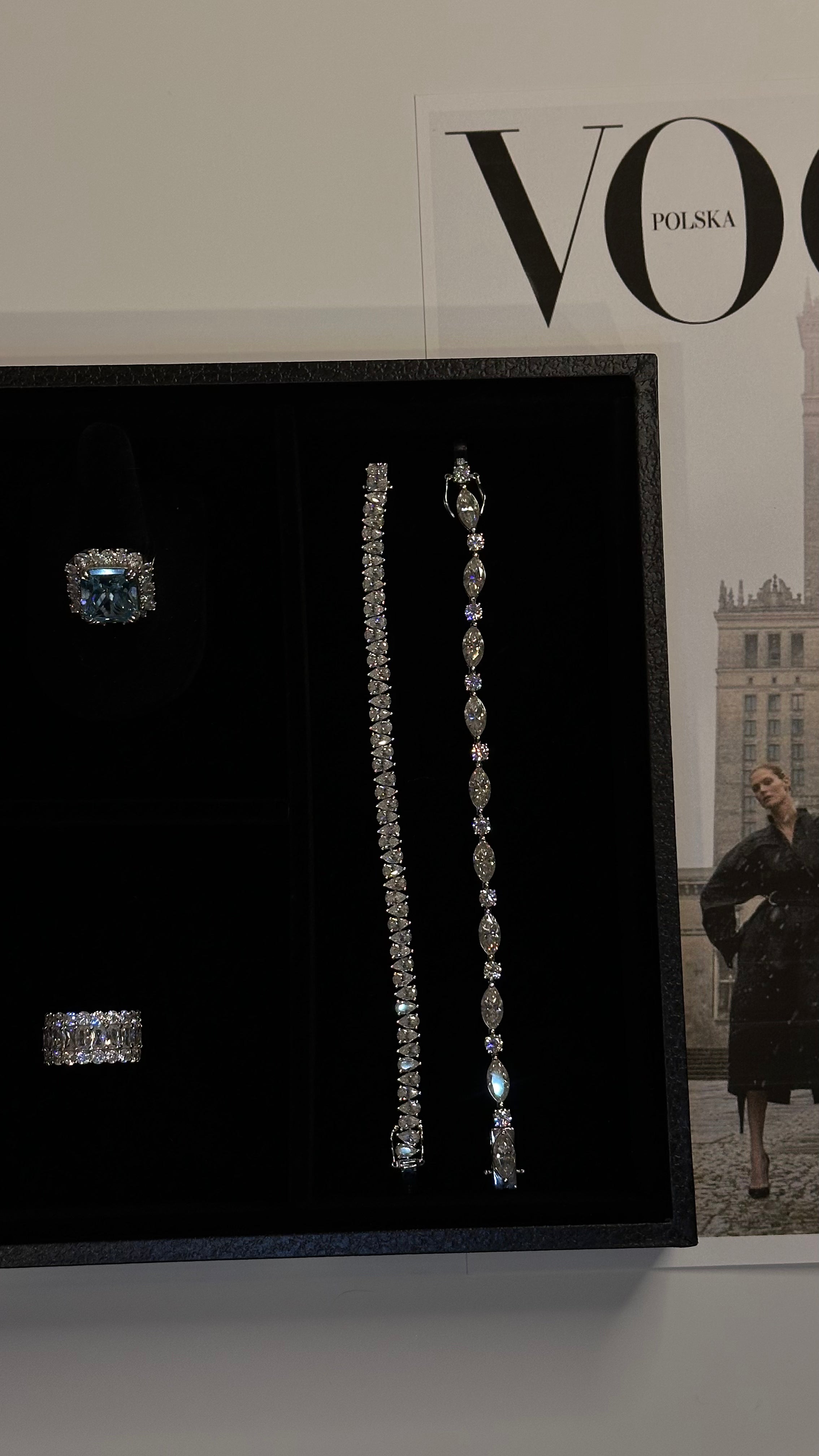 Diamond-free Jewelry by Viviana Halil including ring and earrings displayed on a black stand with 'VOGUE' magazine in the background.