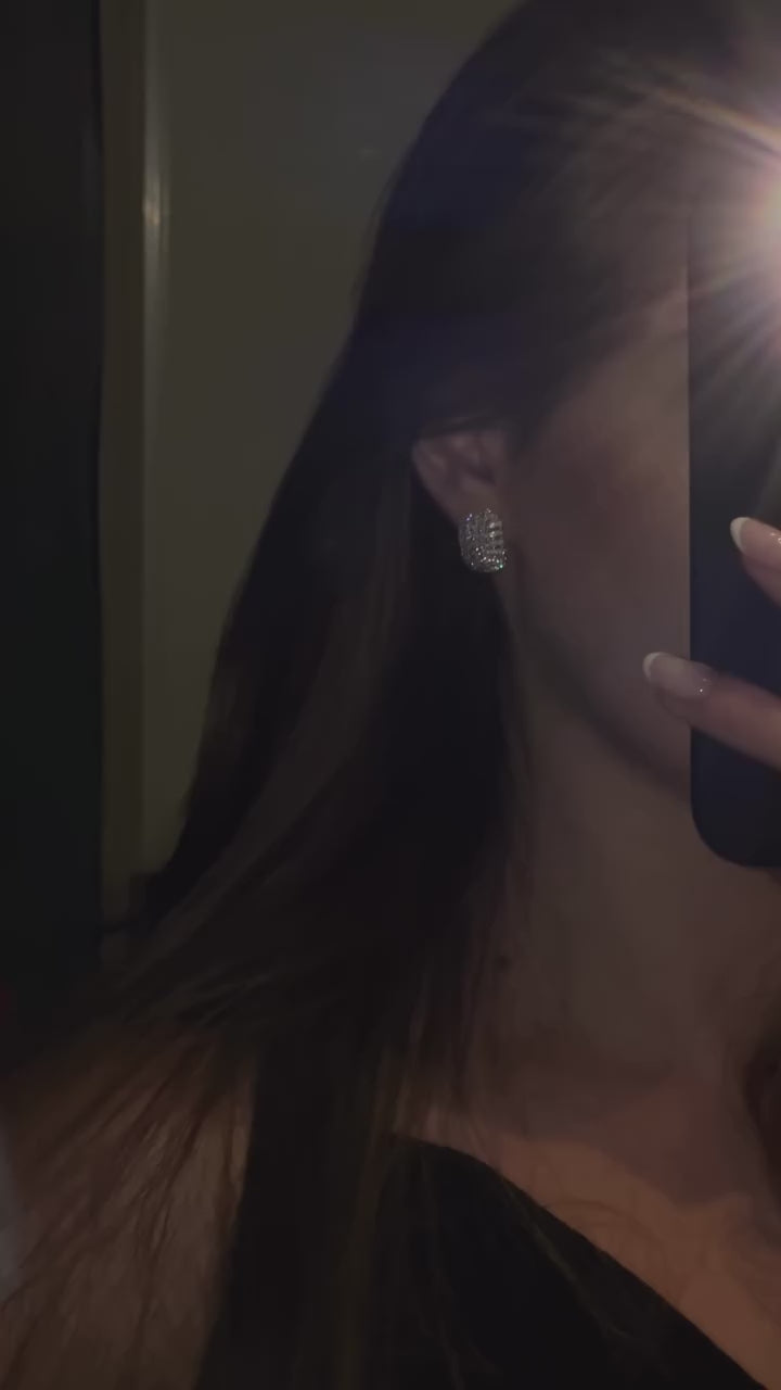 a video close up of the edith earring in sterling silver set with flawless diamond simulants with diamond brilliance.