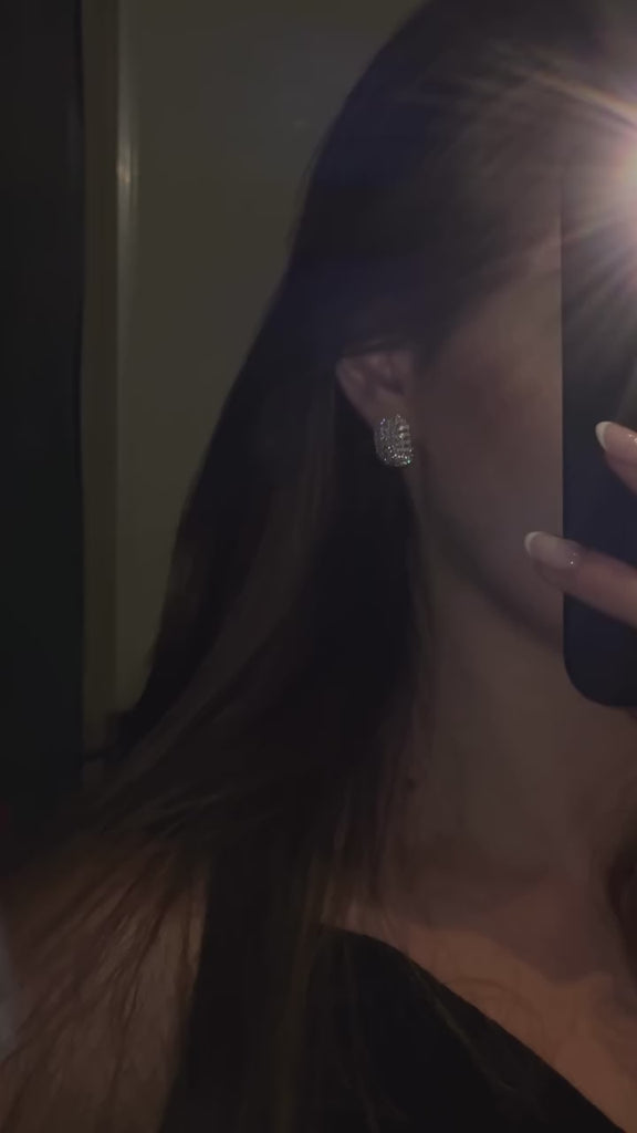 a video close up of the edith earring in sterling silver set with flawless diamond simulants with diamond brilliance.