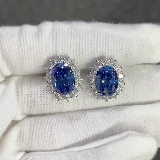 The Princess Diana Oval-cut Halo Stud Earrings crafted using pure sterling silver and set with premium VH zirconia showcased by white glove hand.