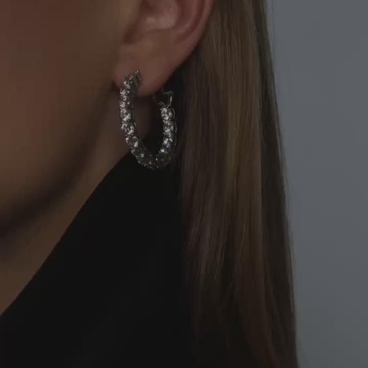Close-up video of model wearing Gisele inside out hoop earrings in sterling silver made by diamond alternative jewelry brand Viviana Halil.