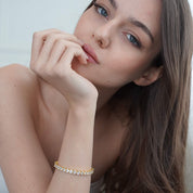 Model wearing The luxxe tenne 18k gold diamond simulant tennis bracelet by Viviana Halil. 