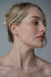 Model wearing The petite luxxe tenne sterling silver tennis necklace featuring a row of premium grade cubic zirconia design by Viviana Halil. 

