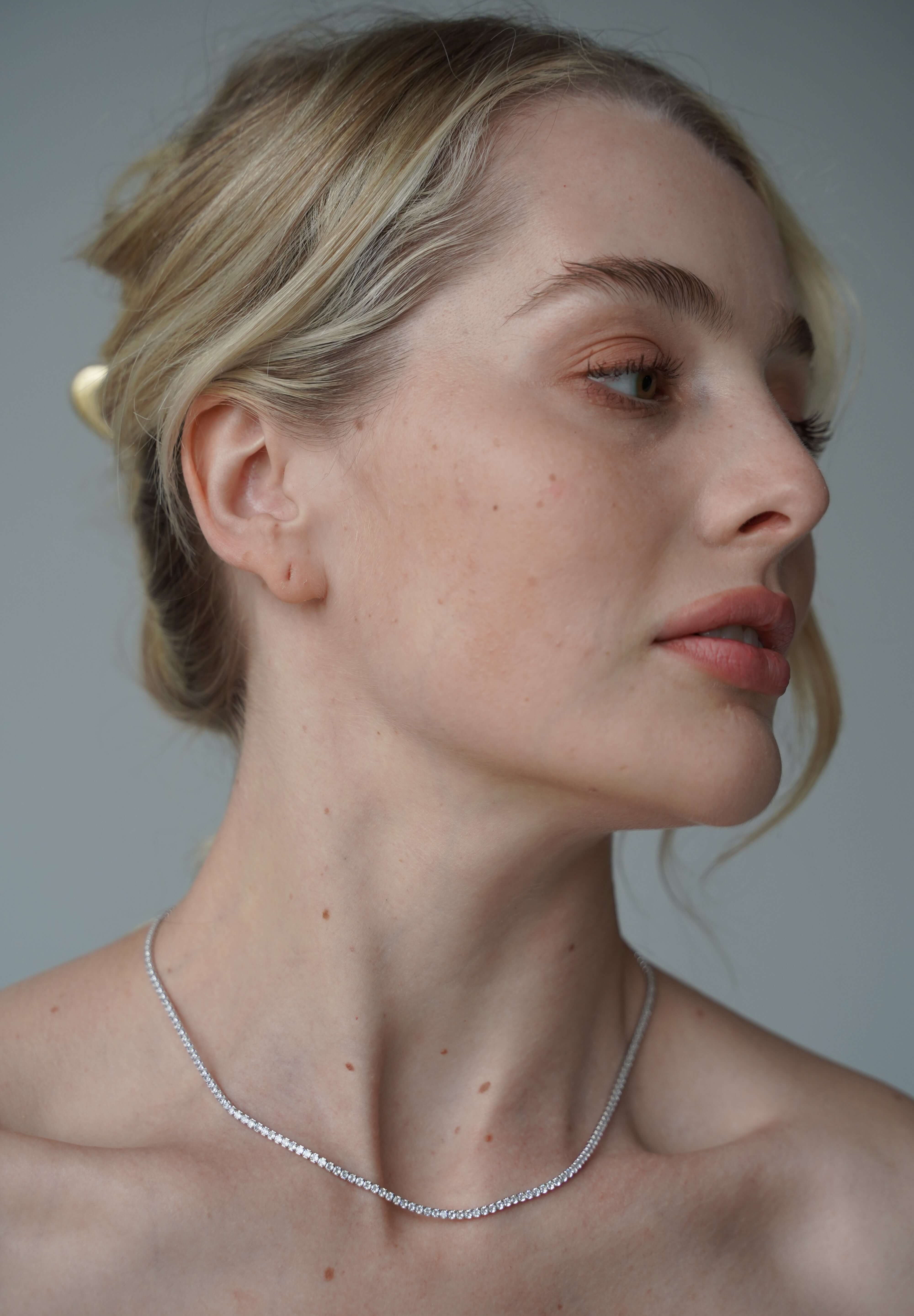 Model wearing The petite luxxe tenne sterling silver tennis necklace featuring a row of premium grade cubic zirconia design by Viviana Halil. 

