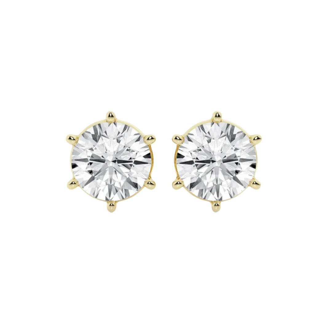 A pair of round-cut stud earrings in moissanite in a six-prong 14k gold setting, shown against a plain white background.